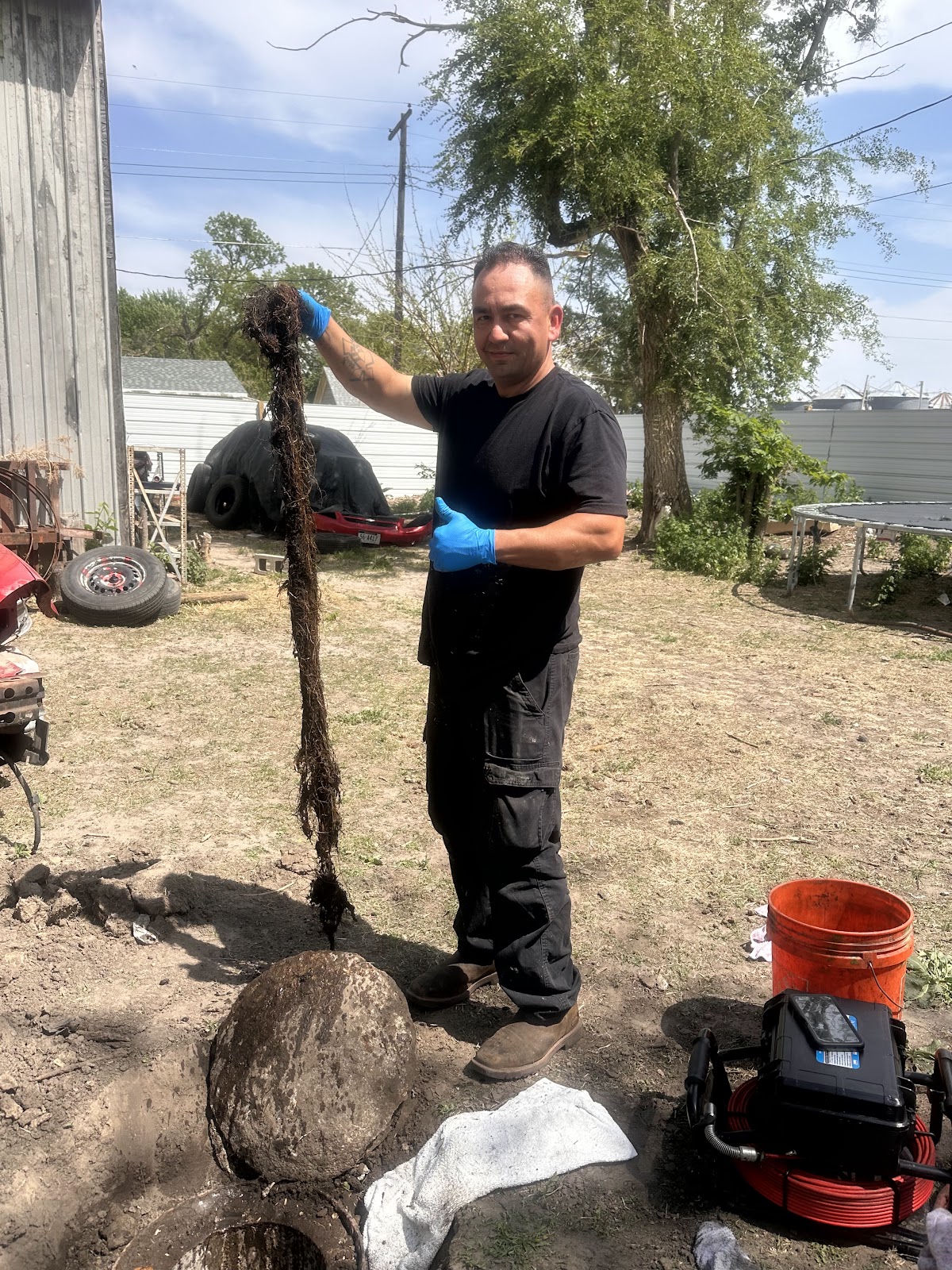Technician holding a long mass of roots pulled from a sewer line
