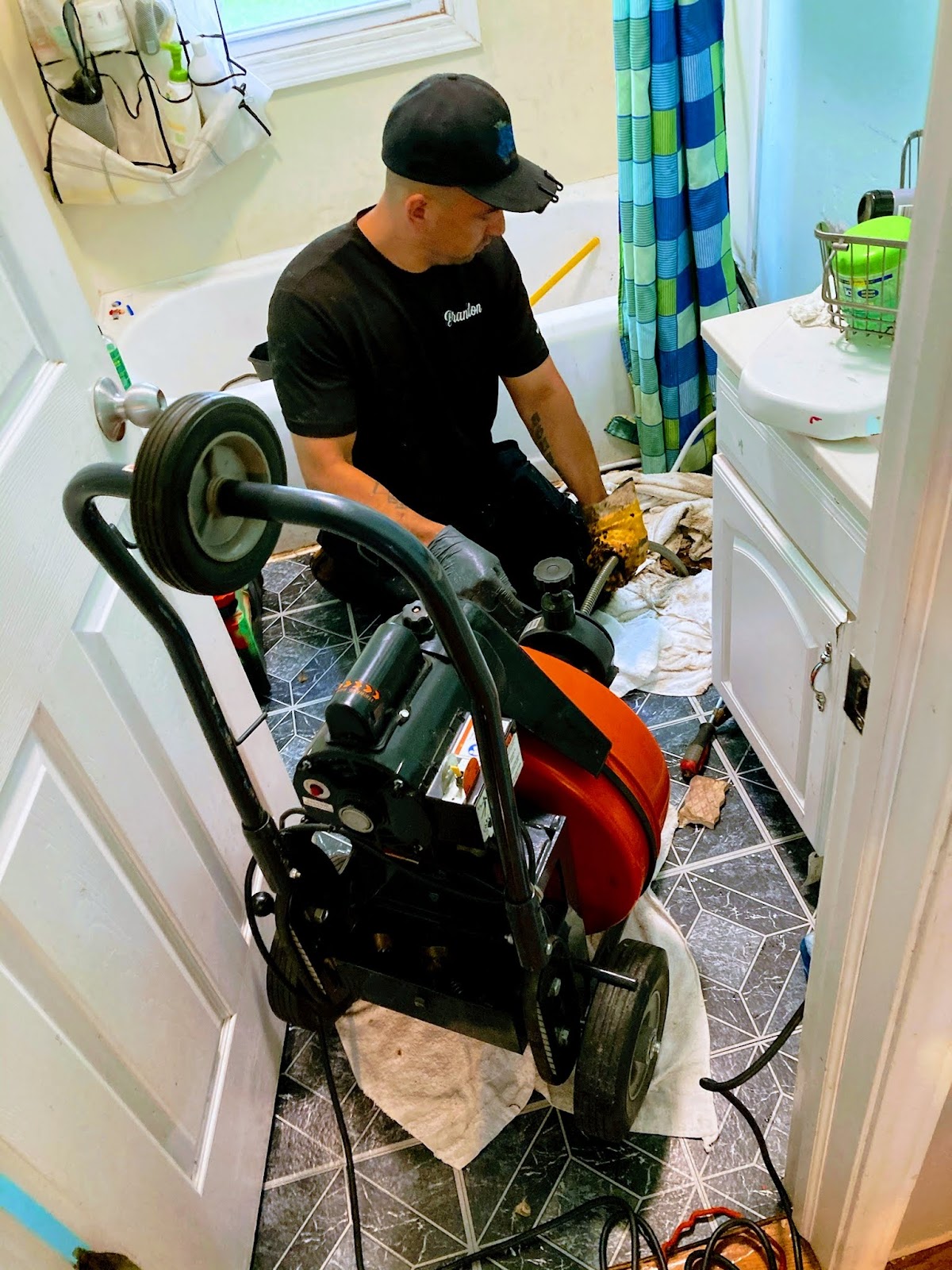 Technician running a drum drain machine in a bathroom